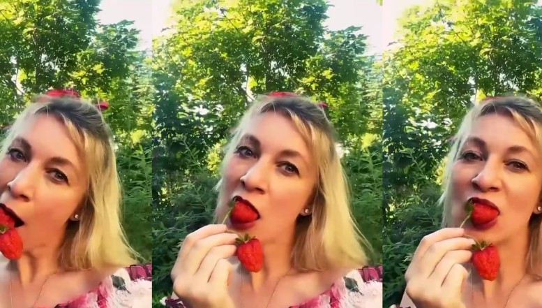 Nebunia oficialilor ruși. Purtătoarea de cuvânt a ministerului lui Lavrov, Maria Zakharova, și-a pus fundă roșie în cap și a mușcat senzual dintr-o căpșună. Reacția ucrainenilor: „porno de proastă calitate”